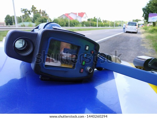 A laser speed detection gun on the hood\
of a police car. Selective focus,\
close-up