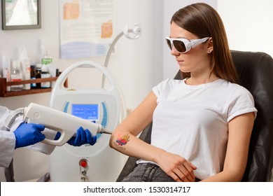 Laser Tattoo Removal At A Shop. Young Girl Getting Rid Of Bad Art On Her Arm. Safe Procedure By Professional Dermatologist.