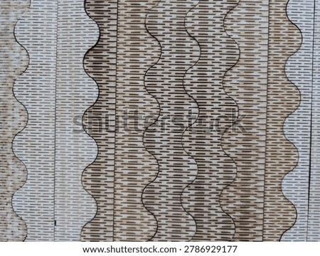 Laser-cut wood pattern displaying undulating waves and fine horizontal dashes under even diffused lighting