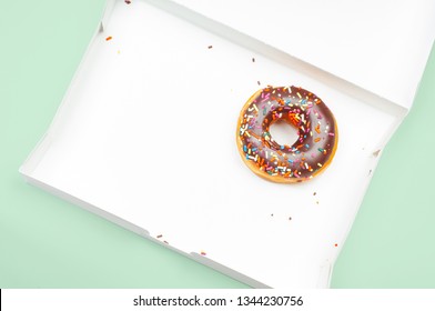  Last Chocolate Donut In Empty Box On Pastel Green Background