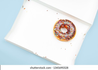  Last Chocolate Donut In Empty Box On Pastel Blue Background