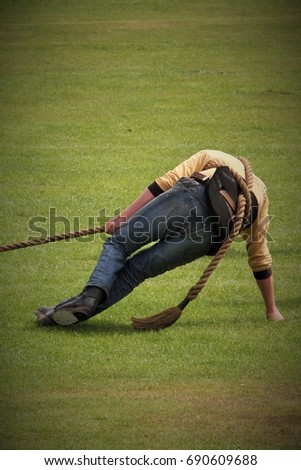 Last man of a tug o war team pulling strongly on the rope during a competition at a Highland games