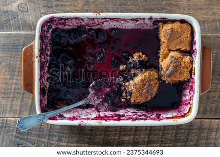 The last pieces of leftover blueberry cobbler in a ceramic baking dish, close up, top view