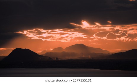 The last rays of the red sunset over the mountain ranges by the Mediterranean Sea