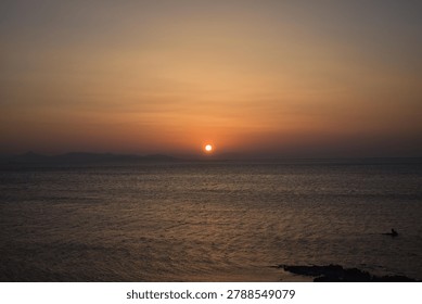 The last rays of the sun setting over the sea horizon