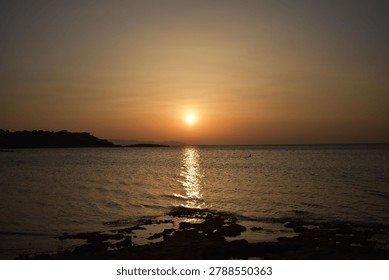The last rays of the sun setting over the sea horizon
