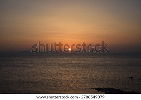 The last rays of the sun setting over the sea horizon