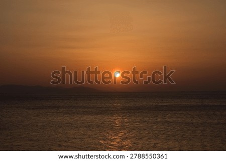 The last rays of the sun setting over the sea horizon