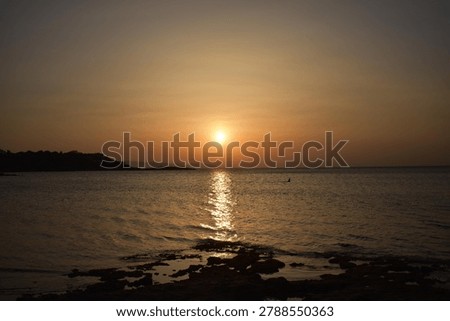 The last rays of the sun setting over the sea horizon