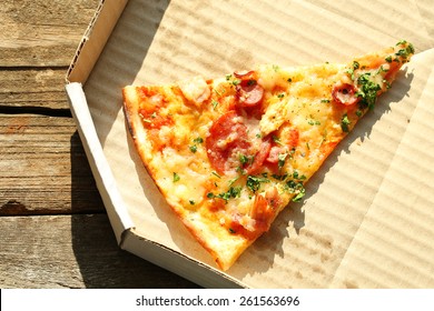 Last Slice Of Pizza On Wooden Table