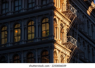 Last sun rays on Soho loft buildings with facade ornamentation and fire escape. Soho Cast Iron Building Historic District along lower Broadway, Lower Manhattan, New York City