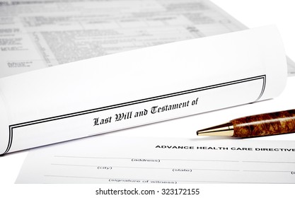 Last Will And Testament Rolled Up With Advance Health Care Directive Isolated On White With A Pen