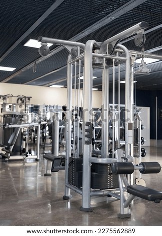 Lat pull down machine standing in middle of gym