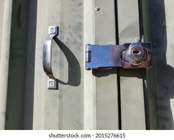 Latch Lock And Handle To Green Garden Shed Door On Sunny Day.