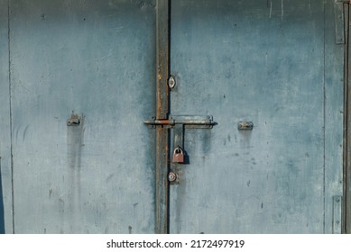 cierre en la puerta del garaje con candado. puerta de garaje de metal antiguo cerrada con candado.  Cárcel antirrobo en la puerta. con asideros, cerradura y bisagras. Puerta cerrada bloqueada