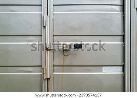 Latch on the rear door of a silver metallic horse trailer