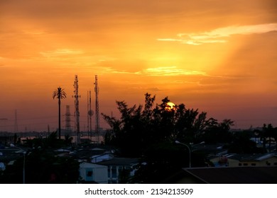 Late Afternoon Sunset In Lagos, Nigeria With Trees And Communication Towers In The Foreground.