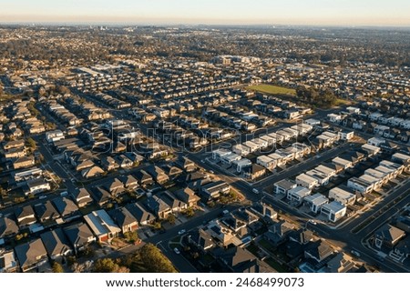 Late afternoon, wide aerial view of streets and similar sized modern Australian homes in Sydney's rapidly growing and increasingly sprawling outer suburbs