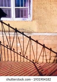 Late Evening Shadows Of A Compound Gate On The Walls And Tiled Floor Of An Old Lower Middle Class Home In Mumbai.