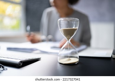 Late Invoice And Billing Deadline With Hourglass At Desk