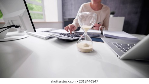 Late Invoice And Billing Deadline With Hourglass At Desk - Shutterstock ID 2312446347