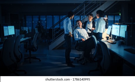 Late At Night In Modern Office: Diverse Team Of Successful And Ambitious Businessmen And Businesswomen Work On Computer, Having Discussion, Finding Problem Solution, Finishing Project Together.