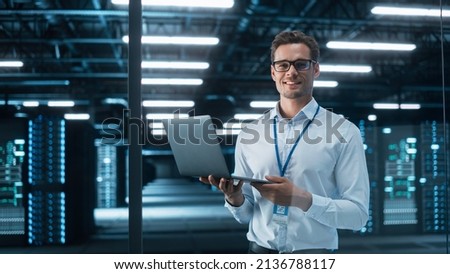 Late at Night in Private Office Male Businessman Works on a Laptop Computer. He Look at the Camera with Smile. Data Protection Engineering Network for Cyber Security. Business Concept Foto stock © 