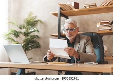 Late Payment, Court Notice. Surprised Mature Man Looking Through The Subpoena In The Office At The Desk, Fine Or Bankruptcy.