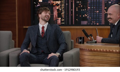 Late-night Talk Show Host Having A Funny Conversation With Celebrity Male Guest In A Studio. TV Broadcast Style Show