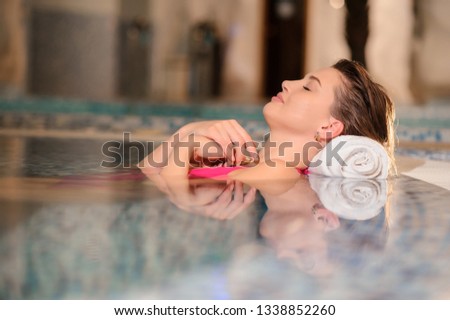 lateral view of a beautiful woman wearing swimsuits relaxing swimming pool