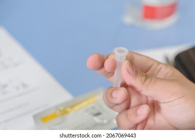 Lateral-Flow-Test Covid Rapid Home-use Test Kit For Saliva - Step 2 - Spit With Mouth Through Funnel In Plastic Tube To Collect Sample.