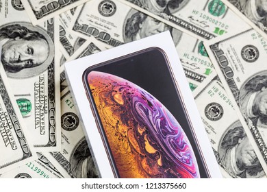 Latest Iphone XS in unopened box on US dollar banknotes background.