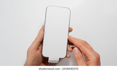 Latest new green titanium smartphone with screen protecting sticker. Brand new phone. Flagship mobile phone 2024. Top view. - Powered by Shutterstock