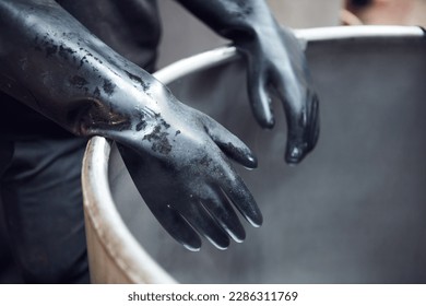 Latex industrial chemical rubber gloves protecting hands from toxic acidic chemical compounds in an industrial chemical factory. Acid bath and virus protection marigold latex gloves.