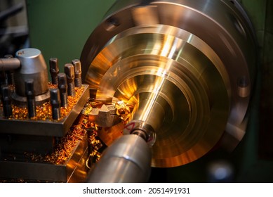 The lathe machine finishing cut the brass shaft parts by lathe tools. The metalworking process by turning machine.