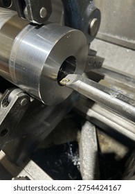 Lathe performing precision boring operation on a steel component in manufacturing workshop