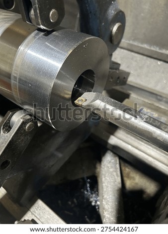 Lathe performing precision boring operation on a steel component in manufacturing workshop