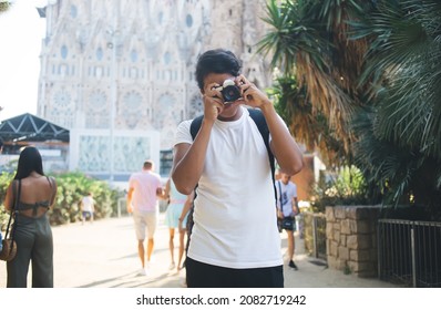 Latin amateur using vintage camera for catch photo focus during touristic trip to Barcelona, professional photographer taking images of Catalonia streets in Spain standing near Sagrada Familia
