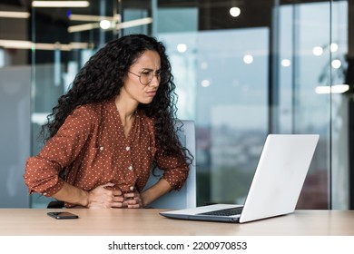 Latin American Business Woman Is Sick At Work, Employee With Curly Hair And Glasses Has Severe Stomach Pain, Businesswoman Working Inside Office Building Using Laptop.