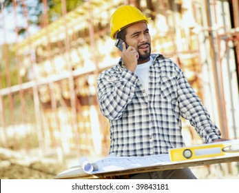 Latin American Construction Worker Talking On Mobile Phone. Copy Space