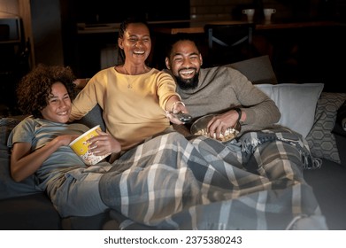 Latin American family watching a movie at home over a streaming cable service. Movie night. Family bonding - Powered by Shutterstock