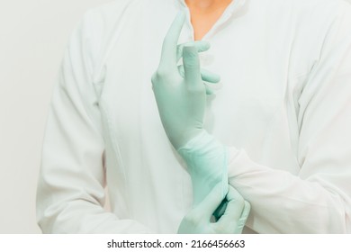 Latin American Female Doctor In White Coat Putting On Gloves