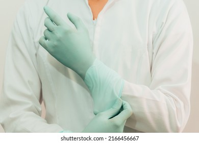 Latin American Female Doctor In White Coat Putting On Gloves