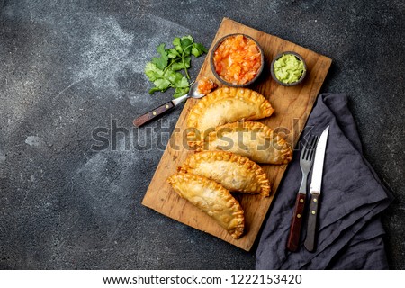Latin American fried empanadas with tomato and avocado sauces. Top view.