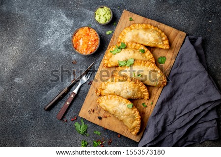Latin American fried empanadas with tomato and avocado sauces. Top view.