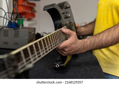 Latin American luthier tilts electric guitar on its side to check its condition after repair. Unrecognizable person. Concept repair, instrument, guitar