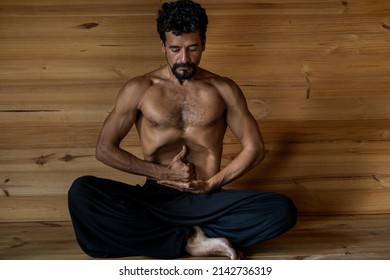 Latin American Male Yogi Sitting Practicing Nauli Kriya With Limgan Mudra. Concept Of Yoga And Meditation