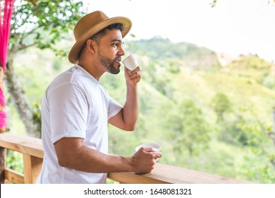 Latin American Man Drinking Coffee in the Mountain. Young Man Having Breakfast in the Morning. Latino Guy Wearing Hat and Drinking Tea. Lifestyle Concept.