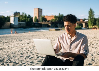 Latin American Man Working With His Laptop On The Beach