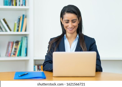 Latin American Mature Businesswoman With Blazer At Computer At Office